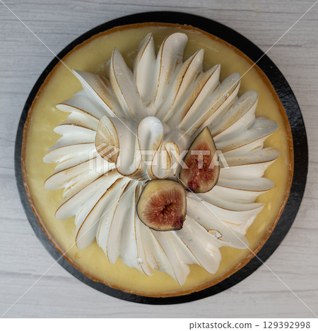 Sunny and Bright Orange Lemon Citrus Meringue Pie on a black plate on white background Sunny and Bright Orange Lemon Citrus Meringue Pie on a black plate on white background 129392998