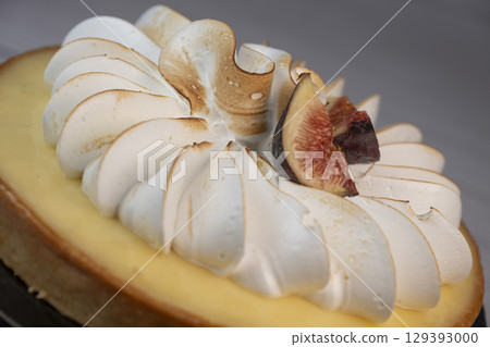 Sunny and Bright Orange Lemon Citrus Meringue Pie on a black plate on white background 129393000