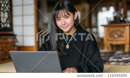 Young japanese girl working on laptop in traditional Japanese room with wooden decor Young japanese girl working on laptop in traditional Japanese room with wooden decor 129393094