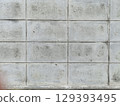 Close up view of weathered concrete wall with visible stains, cracks, and dirt, showing aged and rough surface texture 129393495