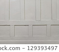 Plain white wooden wall with vertical and horizontal panels smooth surface simple background neutral color indoor setting minimal texture clean 129393497