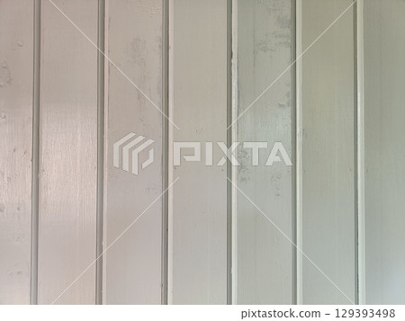 Close up of painted wooden wall panels with vertical grooves, smooth surface, and subtle color variations creating calm and neutral background 129393498