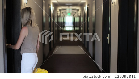 Woman with suitcase in the hallway at the hotel. Check in at the hotel. Showcasing a modern travel experience. Woman with suitcase in the hallway at the hotel. Check in at the hotel. Showcasing a modern travel experience. 129393811