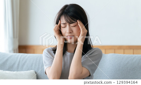 A woman holding her head in distress A woman holding her head in distress 129394164