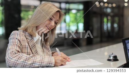 Woman signs papers, takes keys and talks to female. Woman signs papers, takes keys and talks to female manager. 129394353