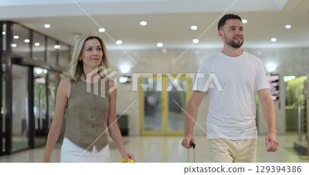 Young people arriving at beautiful hotel reception. Travel and reception desk concept. 129394386