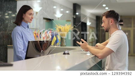 Man frustrated for argument, mistake in hotel lobby. Conflict, customer and manager with dispute, angry booking crisis and upset with service. Man frustrated for argument, mistake in hotel lobby. Conflict, customer and manager with dispute, angry booking crisis and upset with service. 129394392