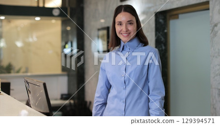 Professional woman manager of hotel at reception looking at camera. Concierge service, woman smile in lobby for check in assistance, reservation and help. Professional woman manager of hotel at reception looking at camera. Concierge service, woman smile in lobby for check in assistance, reservation and help. 129394571