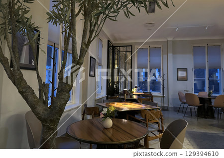 An intimate interior shot of a stylish, modern cafe or restaurant with a minimalist aesthetic. An intimate interior shot of a stylish, modern cafe or restaurant with a minimalist aesthetic. 129394610