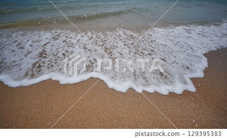 Soft waves gently lapping the sandy shore of crimea, creating a tranquil scene on the black sea coastline Soft waves gently lapping the sandy shore of crimea, creating a tranquil scene on the black sea coastline 129395383