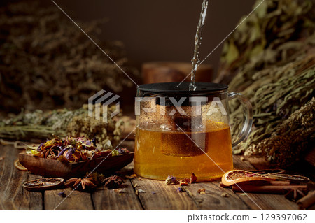 Hot water is poured into a glass teapot. Hot water is poured into a glass teapot. 129397062