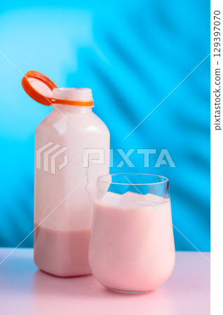 Pink smoothie, vitamin drink, or yogurt on a colorful background. 129397070