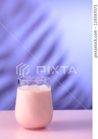 Pink smoothie, vitamin drink, or yogurt on a colorful background. 129397071