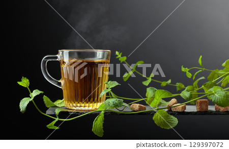 Cup of mint tea and fresh mint sprigs. 129397072