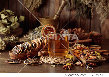 Cup of herbal tea with various dried herbs, flowers, and spices. 129397090