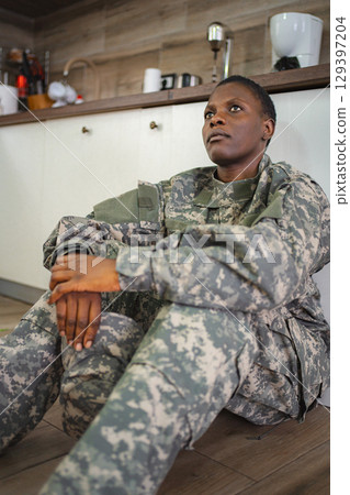 American soldier sitting on the floor looking pensive 129397204