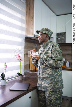 Smiling Soldier Enjoying Breakfast in Kitchen Smiling Soldier Enjoying Breakfast in Kitchen 129397205