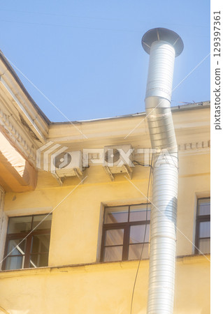 Air conditioners are installed on facade of building. device for comfortable living in hot weather. 129397361
