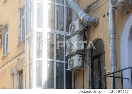 Air conditioners are installed on facade of building. device for comfortable living in hot weather. 129397362