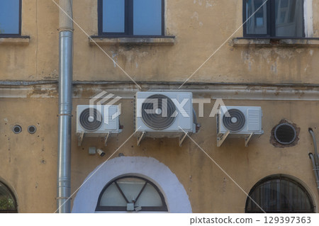 Air conditioners are installed on facade of building. device for comfortable living in hot weather. 129397363