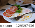 Healthy food, breakfast meal consist of egg, tomato, on white plate on a marble table. 129397436