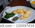 Scrambled Eggs on frying pan for healthy breakfast or brunch, top view, copy space. Homemade meal recipe - scrambled eggs on black background. 129397438