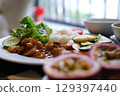 Healthy Meal with Grilled Chicken, Rice, Salad, and Vegetables Served by Woman 129397440