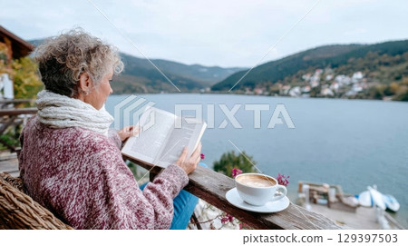 Solo traveler enjoying a peaceful moment reading a book by the serene lake, surrounded by nature's beauty and a cozy atmosphere of self-discovery 129397503