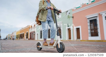 Solo traveler riding electric scooter through vibrant street, showcasing modern lifestyle and adventure in a colorful urban environment 129397509
