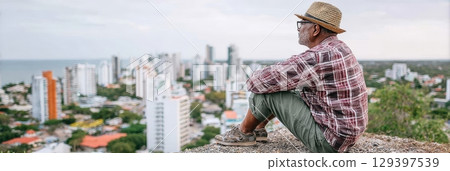 Solo traveler enjoying breathtaking city view while reflecting on life, embracing freedom and adventure in a modern urban landscape 129397539