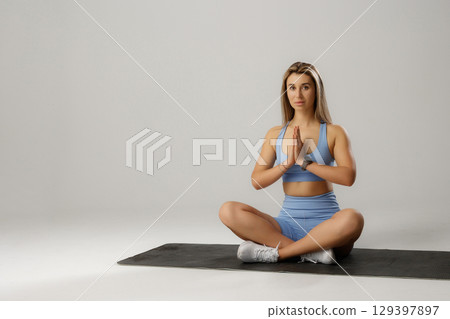 Young woman practicing yoga in comfortable studio setting while focusing on mindfulness and relaxation techniques Young woman practicing yoga in comfortable studio setting while focusing on mindfulness and relaxation techniques 129397897