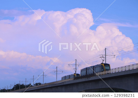 Utsunomiya City: LRT crossing the Kinugawa River and thunderclouds 129398231