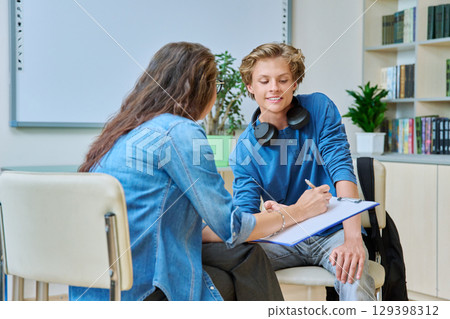 Teenage student guy with school counselor, coach in meeting room 129398312