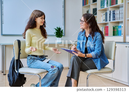 Teenage student girl at therapy session with mental health counselor 129398313