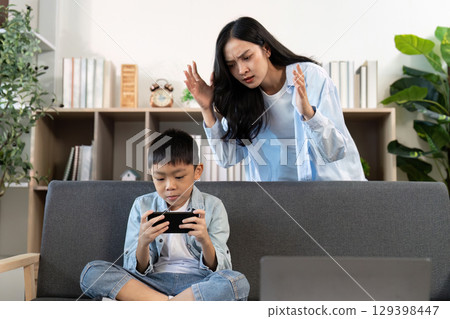 Mother scolding son for excessive gaming at home Mother scolding son for excessive gaming at home 129398447