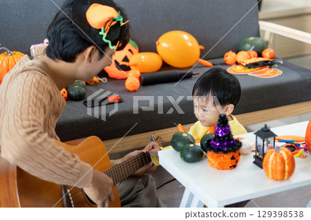 Halloween Fun. Father sharing musical moments with son surrounded by decorations. Halloween Fun. Father sharing musical moments with son surrounded by decorations. 129398538