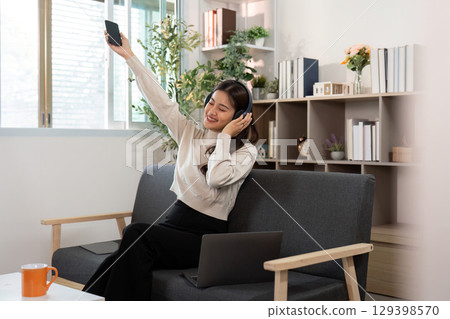 Joyful Music Experience. Woman dancing with phone at home. Joyful Music Experience. Woman dancing with phone at home. 129398570