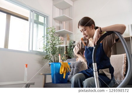 Home Cleaning. Tired woman taking a break while vacuuming. Home Cleaning. Tired woman taking a break while vacuuming. 129398572