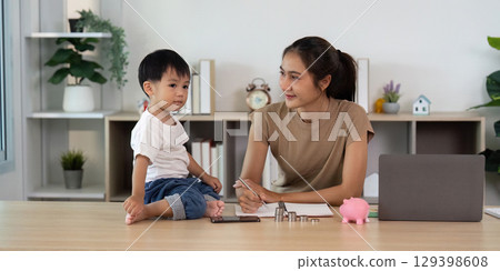 Financial Planning: Child and Parent Discussing Savings Strategy with Piggy Bank Financial Planning: Child and Parent Discussing Savings Strategy with Piggy Bank 129398608