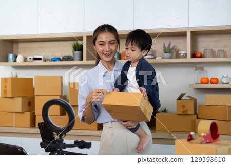 Mother and child engaging in home business with packaging boxes Mother and child engaging in home business with packaging boxes 129398610