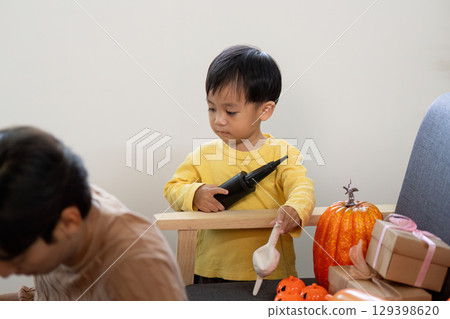 Halloween Fun. A young boy preparing decorations with pumpkins and crafts. 129398620