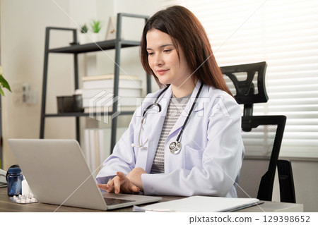 Telemedicine Consultation. A doctor engaging with patients online from a modern office. 129398652