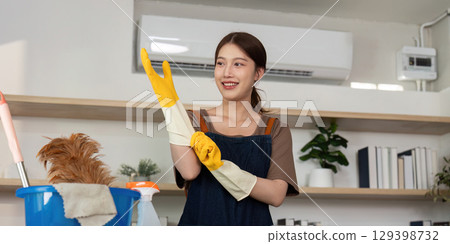 Home Cleaning. Woman preparing for cleaning with gloves. 129398732