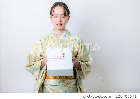 一位身著振袖和服的女子,手裡拿著仲夏禮物 一位身著振袖和服的女子,手裡拿著仲夏禮物 129400571