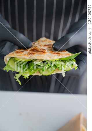 Chef holding a flatbread with herbs.  129400732