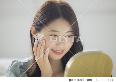 一名年輕女子正在做皮膚護理 一名年輕女子正在做皮膚護理 129400745