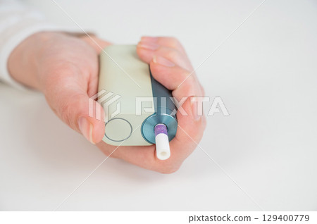 Woman holding electronic cigarette on white background. Tobacco heating systems. Woman holding electronic cigarette on white background. Tobacco heating systems. 129400779