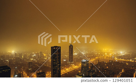 A foggy urban nightscape filled with luminous city lights illuminating the streets at dusk A foggy urban nightscape filled with luminous city lights illuminating the streets at dusk 129401051