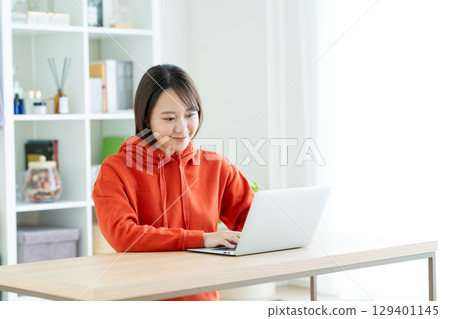 使用一台個人計算機的年輕女子 129401145