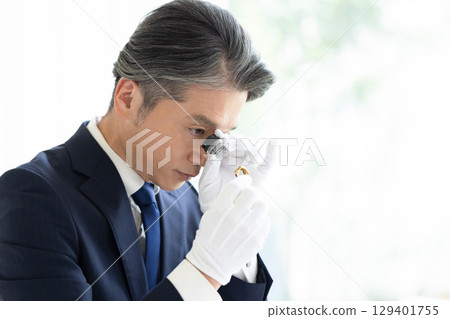 On-site purchase: A man assessing precious metals 129401755